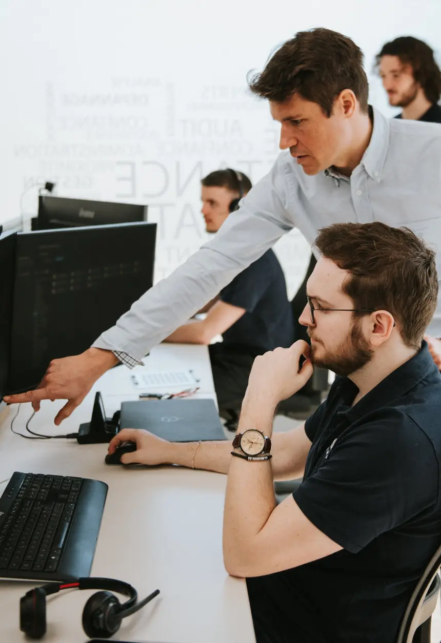 Un technicien elionis accompagne un collègue devant un écran de supervision